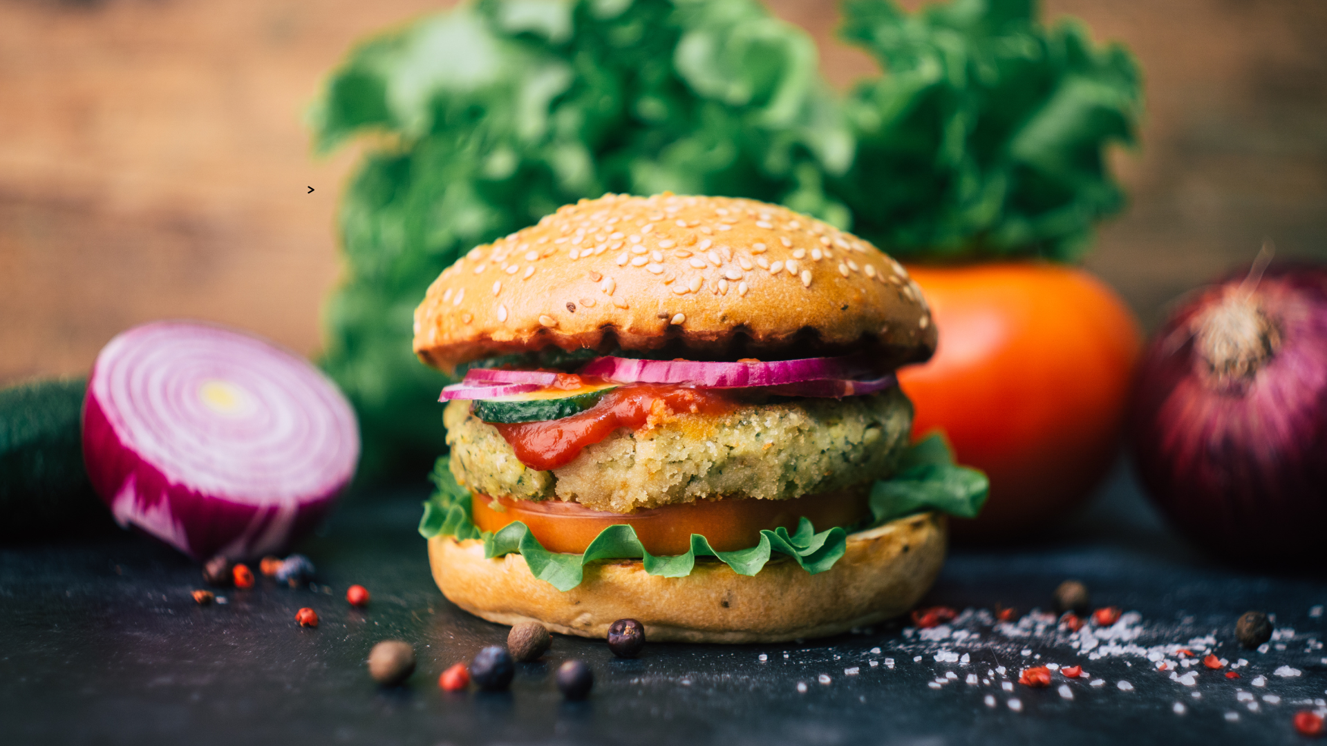 Photo d'une assiette composée d'un burger et de différents légumes.